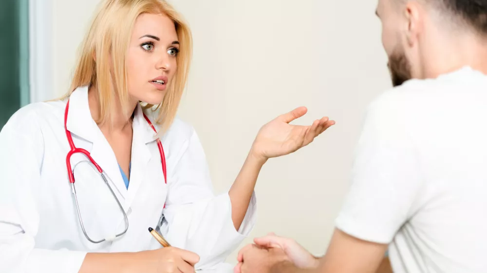 Woman doctor is talking to male patient in hospital office. Healthcare and medical service. / Foto: Nanostockk