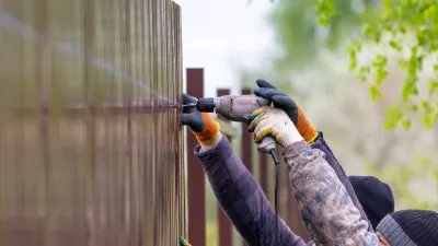 Workers install a metal profile fence. / Foto: Schankz