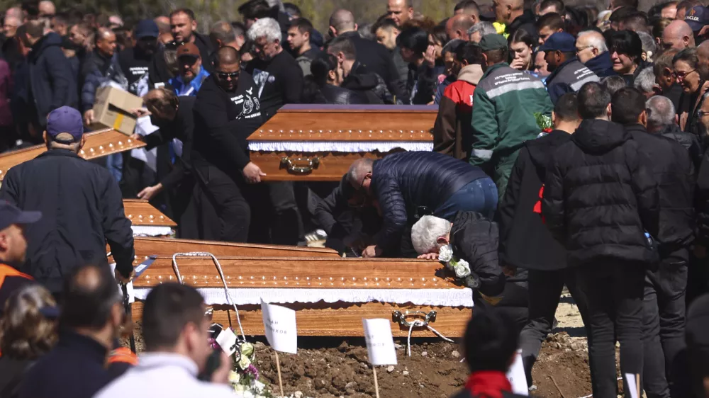 A man cries leaning on a coffin during the funeral ceremony of the victims of a massive nightclub fire in the town of Kocani, North Macedonia, Thursday, March 20, 2025. (AP Photo/Armin Durgut)