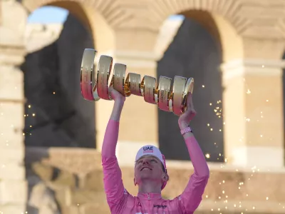 Tour of Italy winner Slovenia's Tadej Pogacar holds up the trophy during the podium ceremony at the end of the 21st and last stage of the Giro D'Italia, cycling race, in Rome, Sunday, May 26, 2024. (AP Photo/Andrew Medichini)
