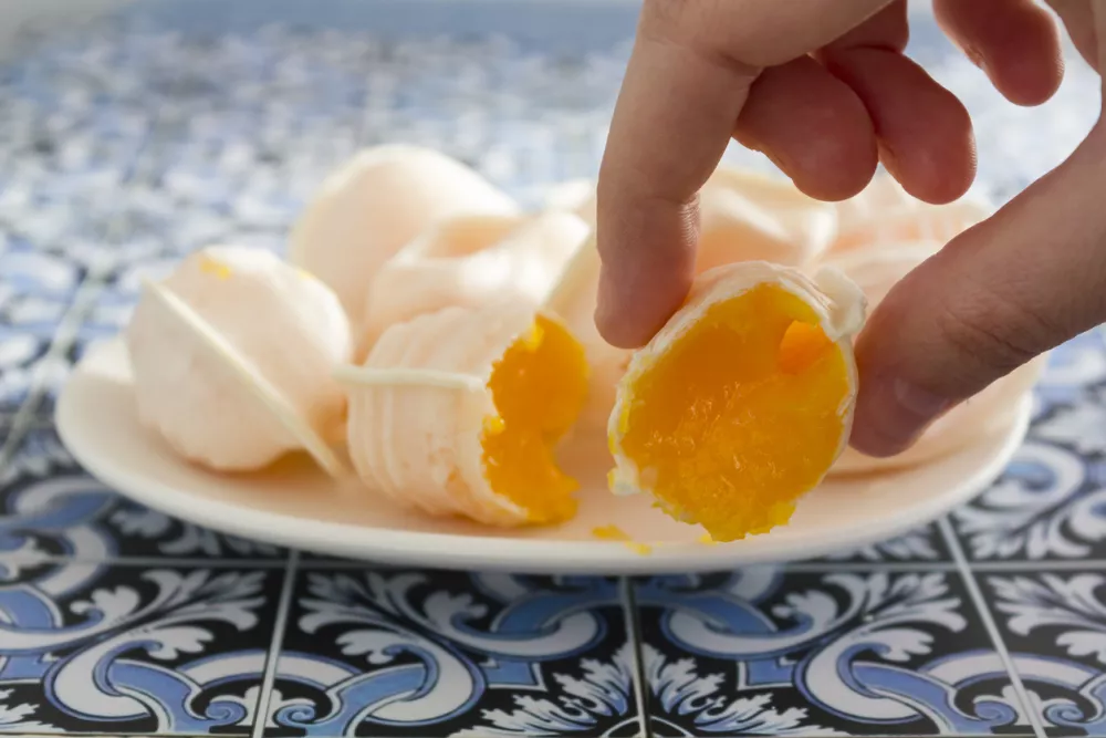 Hand taking a traditional portuguese sweet called Ovos Moles de Aveiro