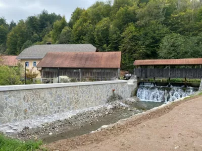 Nadvišan in obložen zid nad mostom z obnovljenim prelivom. Polhov Gradec / Foto: Gradascica.si