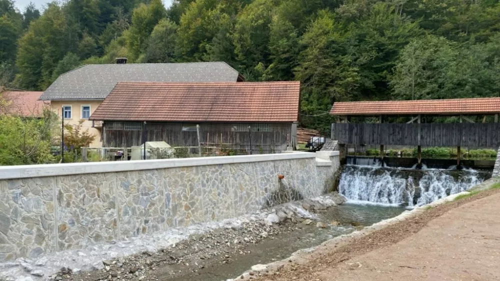 Nadvišan in obložen zid nad mostom z obnovljenim prelivom. Polhov Gradec / Foto: Gradascica.si