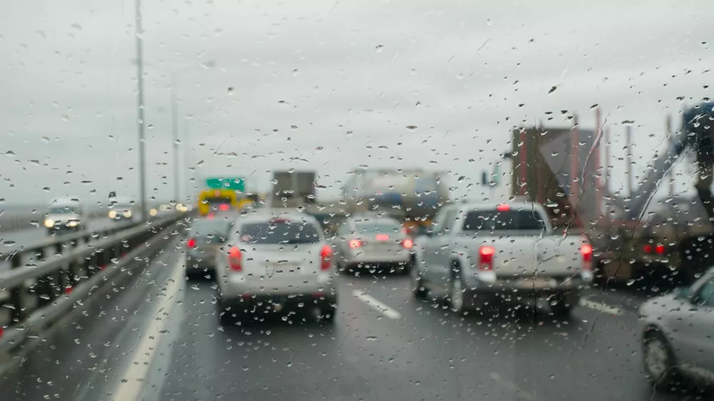 Defocussed traffic viewed through a car windscreen covered in rain, focus on raindrops / Foto: K-paul