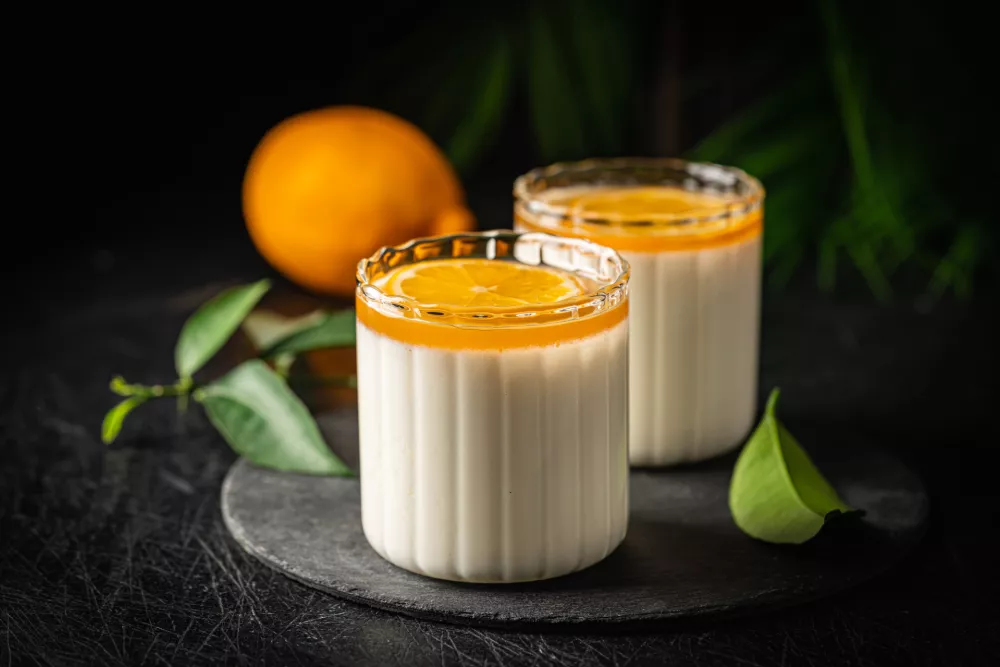 Homemade dessert panna cotta, mousse or pudding in a portion glass with lemon curd and fresh lemon. / Foto: Roxiller