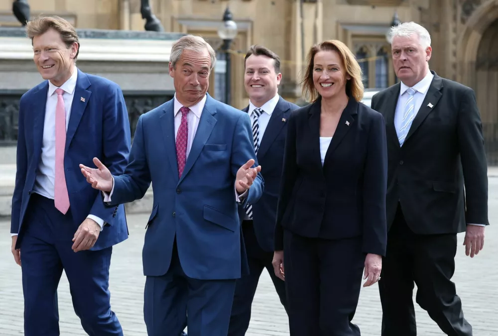 Britain's Reform Party leader, Nigel Farage gestures as he walks with newly elected Reform MP Sarah Pochin, together with fellow Reform MPs Richard Tice, James McMurdock, and Lee Anderson, into the Houses of Parliament in London, Britain, May 6, 2025. REUTERS/Toby Melville / Foto: Toby Melville