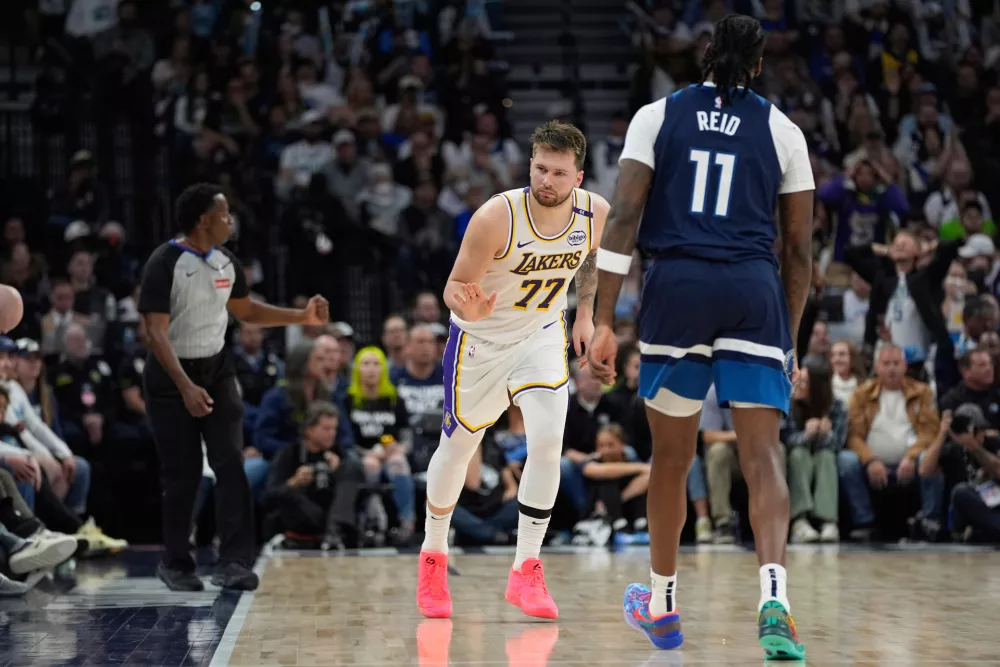 Los Angeles Lakers guard Luka Doncic (77) gestures next to Minnesota Timberwolves center Naz Reid (11) after making a 3-point shot during the first half of Game 4 of an NBA basketball first-round playoff series, Sunday, April 27, 2025, in Minneapolis. (AP Photo/Abbie Parr) / Foto: Abbie Parr