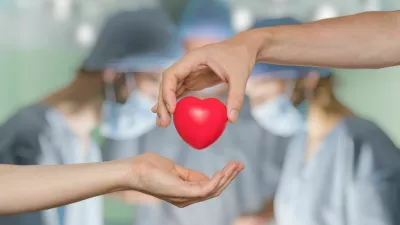 Heart transplant and organ donation concept. Hand is giving red heart. / Foto: Vchal