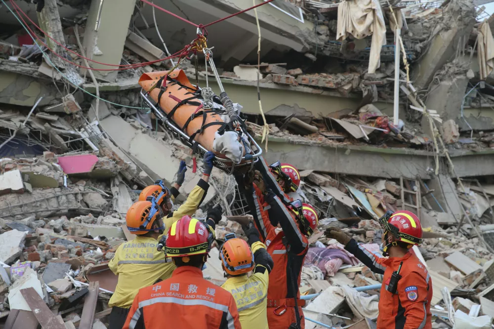 In this photo released by Xinhua News Agency, members of a China search and rescue team transfer a pregnant survivor from a collapsed building in the aftermath of an earthquake in Mandalay, Myanmar, Monday, March 31, 2025. (Myo Kyaw Soe/Xinhua via AP)