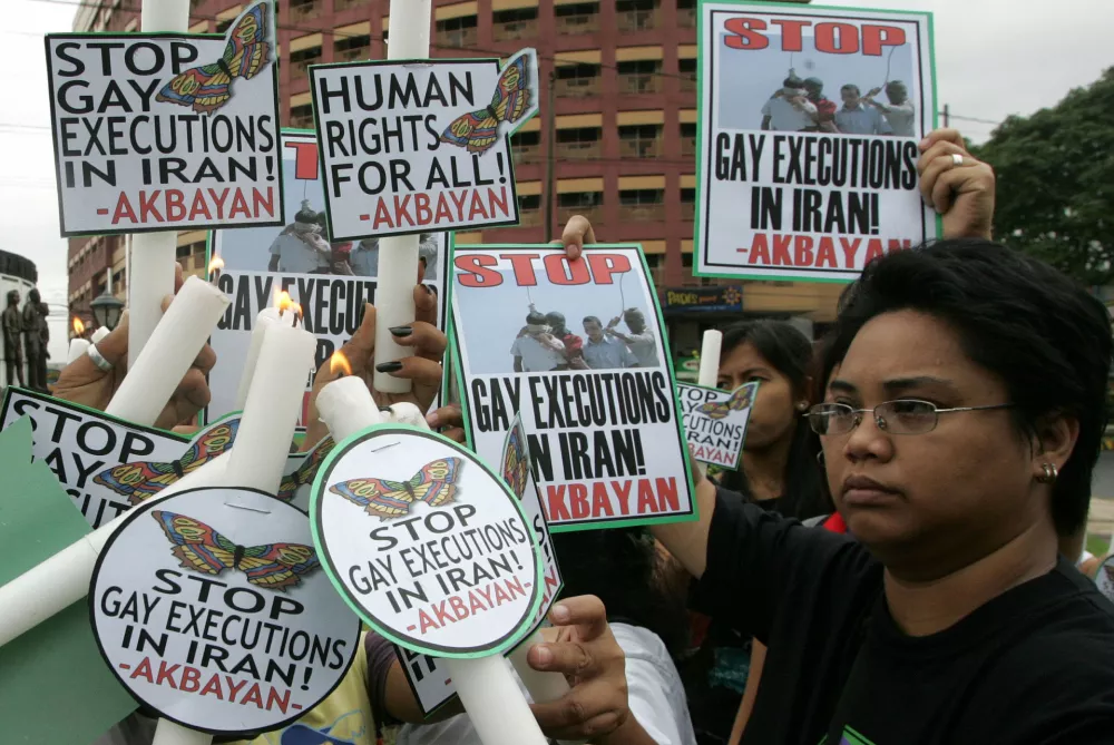 Philippine protesters hold candles and placards to denounce the reported hanging of two homosexual teenage boys in Iran during a protest in Quezon city, suburban Manila, August 5, 2005. The demonstrators protested in front of the Iranian embassy for the abolition of the death penalty and their support for the rights of sexual minorities. REUTERS/Romeo Ranoco