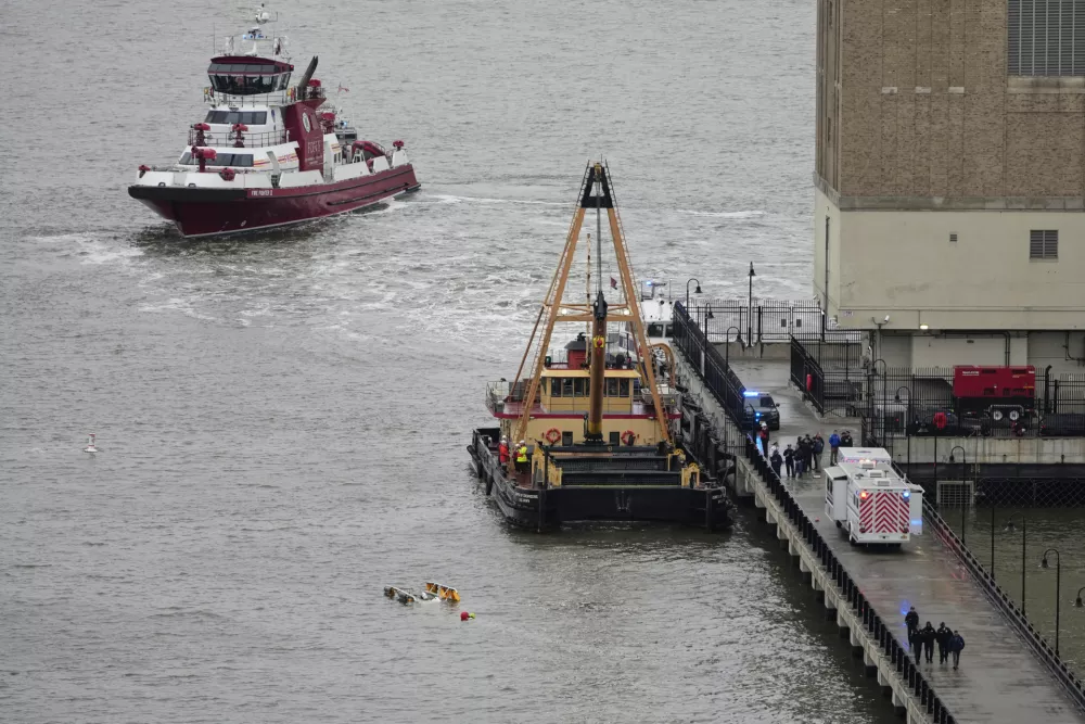 A crane vessel arrives at the scene where a helicopter crashed into the Hudson River, Thursday, April 10, 2025, in Jersey City, N.J. (AP Photo/Seth Wenig)