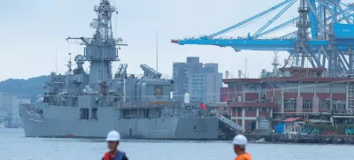 Two staff members look on as navy ships park at the port, as China announces new military drills around Taiwan, in Keelung, Taiwan May 23, 2024. REUTERS/Ann Wang