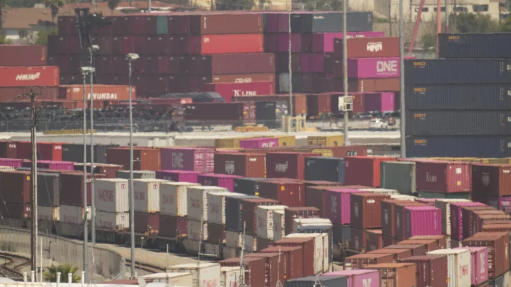 Shipping containers are double-stacked for rail transportation for intermodal shipments at the Port of Los Angeles Wednesday, April 9, 2025, in Los Angeles. (AP Photo/Damian Dovarganes)