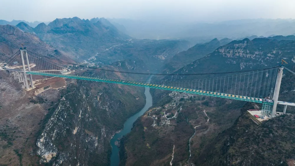ZHENFENG, Jan. 17, 2025 -- An aerial drone photo taken on Jan. 17, 2025 shows a view of the Huajiang Grand Canyon Bridge in southwest China's Guizhou Province. China on Friday finished the construction of the main structure of the Huajiang Grand Canyon Bridge in its southwestern Guizhou Province, which is set to become the world's tallest bridge. A project of Guizhou Transportation Investment Group Co., Ltd., the suspension bridge has a vertical height of 625 meters from the bridge deck down to the river surface. The 2,890-meter bridge, with a span of 1,420 meters, is also the world's largest span bridge to be built in a mountainous area.,Image: 954481489, License: Rights-managed, Restrictions:, Model Release: noFoto: Profimedia
