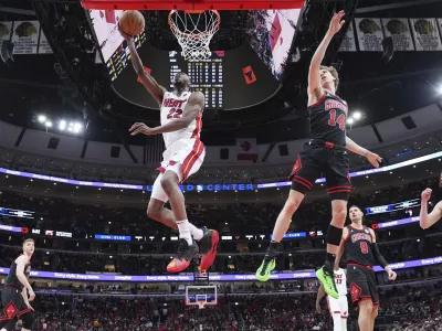 Miami Heat forward Andrew Wiggins, left, drives to the basket past Chicago Bulls forward Matas Buzelis during the first half of an NBA play-in tournament basketball game in Chicago, Wednesday, April 16, 2025. (AP Photo/Nam Y. Huh)