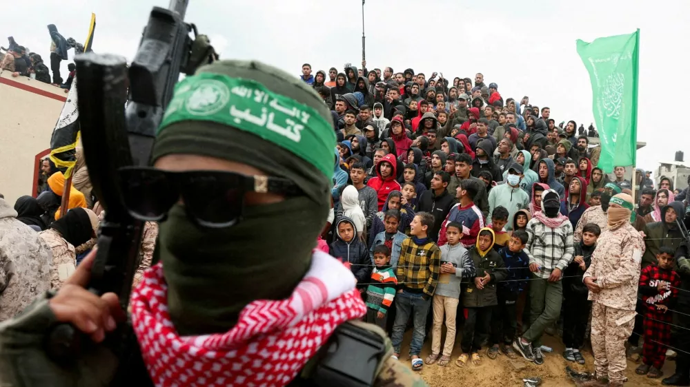 FILE PHOTO: Palestinians look on during the handover by Hamas of deceased hostages, identified at the time by Palestinian militant groups as Oded Lifschitz, Shiri Bibas and her two children Kfir and Ariel Bibas, seized during the deadly October 7, 2023 attack, to the Red Cross, as part of a ceasefire and hostages-prisoners swap deal between Hamas and Israel, in Khan Younis in the southern Gaza Strip, February 20, 2025. REUTERS/Ramadan Abed/File Photo