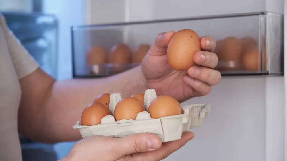Close up of a man putting fresh eggs into refrigerator. / Foto: Ladanifer