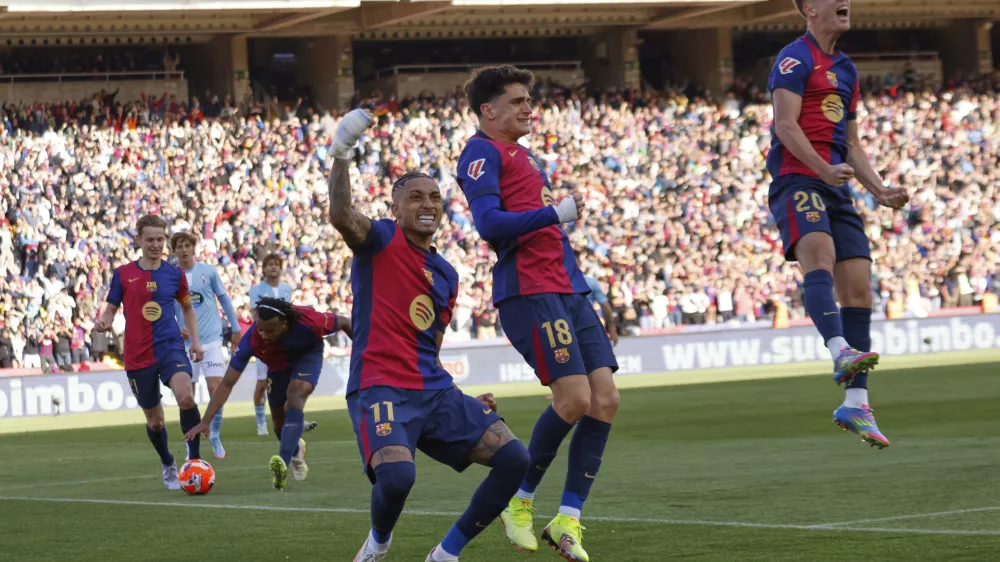 Barcelona's Raphinha, centre left, celebrates with teammates after scoring his side's fourth goal during a Spanish La Liga soccer match between Barcelona and Celta de Vigo at the Lluis Companys Olympic stadium in Barcelona, Spain, Saturday, April 19, 2025. (AP Photo/Joan Monfort)