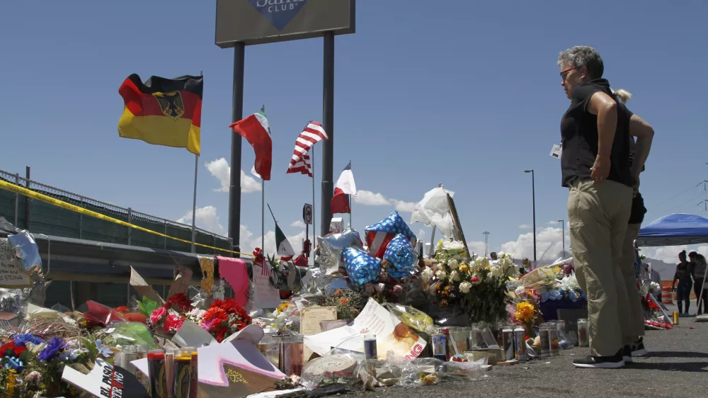 FILE - In this Aug. 12, 2019 photo, mourners visit the makeshift memorial near the Walmart in El Paso, Texas. (AP Photo/Cedar Attanasio, File)