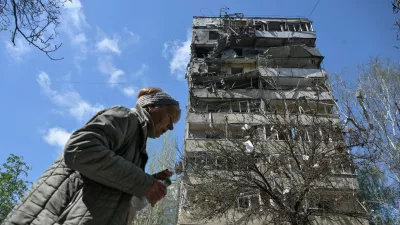 A woman walks near an apartment building hit by a Russian air strike, amid Russia's attack on Ukraine, in Zaporizhzhia, Ukraine April 22, 2025. REUTERS/Stringer   TPX IMAGES OF THE DAY