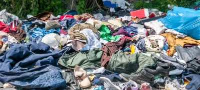 Pile of old clothes and shoes dumped on the grass as junk and garbage, littering and polluting the environment / Foto: Srdjanns74