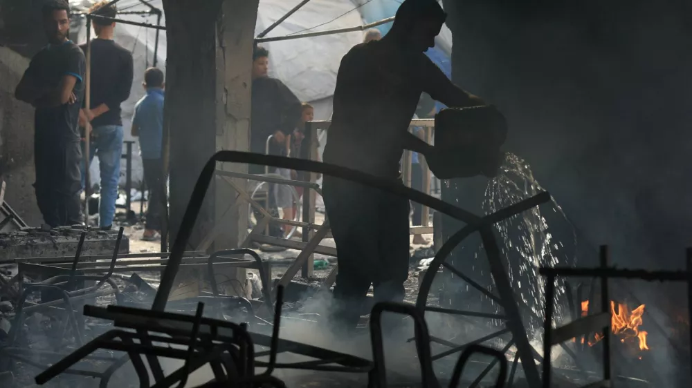 A Palestinian man extinguishes a fire at a school sheltering displaced people, following an Israeli strike, in Gaza City, April 23, 2025. REUTERS/Dawoud Abu Alkas