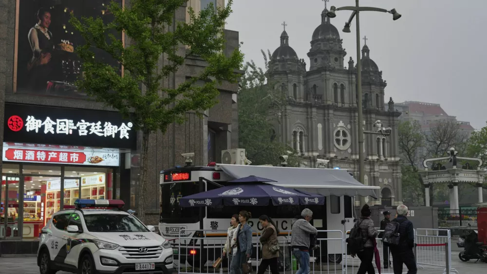 A mobile police station and a police car is parked near the Wangfujing Catholic Church also known as East Church in Beijing, Monday, April 21, 2025. (AP Photo/Ng Han Guan)