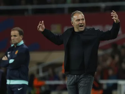 Barcelona's head coach Hansi Flick, right, after Barcelona's Dani Olmo, left, scored his side's opening goal during a Spanish La Liga soccer match between Barcelona and Mallorca at the Lluis Companys Olympic stadium in Barcelona, Spain, Tuesday, April 22, 2025. (AP Photo/Joan Monfort)