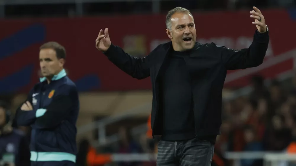 Barcelona's head coach Hansi Flick, right, after Barcelona's Dani Olmo, left, scored his side's opening goal during a Spanish La Liga soccer match between Barcelona and Mallorca at the Lluis Companys Olympic stadium in Barcelona, Spain, Tuesday, April 22, 2025. (AP Photo/Joan Monfort)