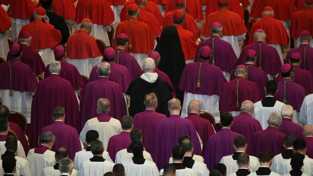 Cardinals, in red, and prelates attend the procession of the body of Pope Francis inside St. Peter's Basilica at the Vatican, Wednesday, April 23, 2025, where he will lie in state for three days.   Andrew Medichini/Pool via REUTERS