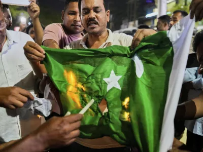 People burn a Pakistani flag in protest against the killing of tourists by militants a day after militants indiscriminately opened fire on tourists near Pahalgam in Indian controlled Kashmir, in Guwahati, India, Wednesday, April 23, 2025. (AP Photo/Anupam Nath)