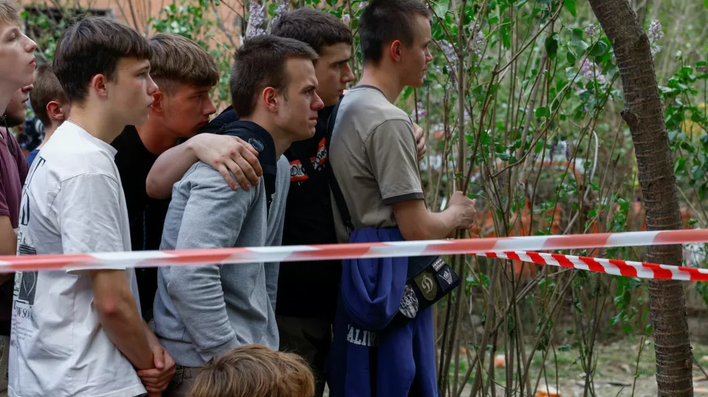 Young people wait while rescuers search for their 17-year-old friend Danylo Khudia and his parents at the site of an apartment building hit by a Russian missile strike, amid Russia's attack on Ukraine, in Kyiv, Ukraine April 24, 2025. REUTERS/Valentyn Ogirenko