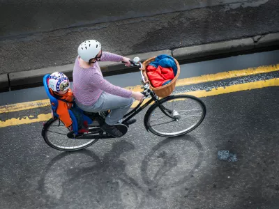 DB6EEK A woman riding a bike with a child in the child bike seat. Image shot 04/2013. Exact date unknown.Foto: Reuters/Alamy