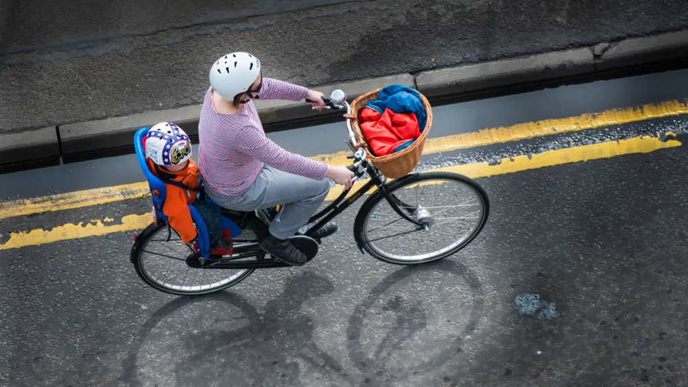 DB6EEK A woman riding a bike with a child in the child bike seat. Image shot 04/2013. Exact date unknown.Foto: Reuters/Alamy