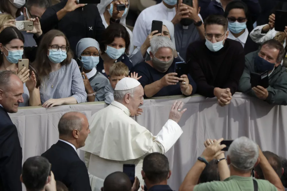 ﻿People wear face masks to prevent the spread of COVID-19 while Pope Francis waves as he arrives for his first general audience with faithful since February when the coronavirus outbreak broke out, in the San Damaso courtyard at the Vatican, Wednesday, Sept. 2, 2020. (AP Photo/Andrew Medichini) / Foto: Andrew Medichini