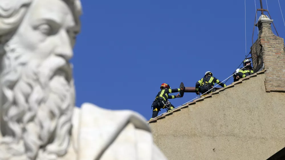 02 May 2025, Italy, Rome: Firefighters fix the chimney on the roof of the Sistine Chapel, where cardinals will gather to elect a new pope, at the Vatican. Photo: Alessia Giuliani/IPA via ZUMA Press/dpa / Foto: Alessia Giuliani