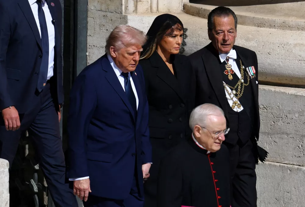 U.S President Donald Trump and first lady Melania Trump walk to attend the funeral Mass of Pope Francis, at the Vatican, April 26, 2025. REUTERS/Kai Pfaffenbach   TPX IMAGES OF THE DAY
