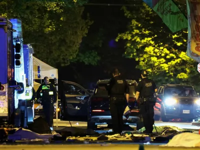 Police officers work by a SUV, which was driven into a crowd at the Lapu Lapu day block party, as bodies of victims lie covered on the ground, in Vancouver, Canada April 27, 2025. REUTERS/Chris Helgren