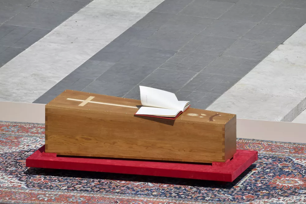 A gust of wind turns the pages of the Gospel book left on the coffin containing the body of late Pope Francis during his solemn funeral in St. Peter's Square at the Vatican Saturday, April 26, 2025. (Vatican Media via AP)