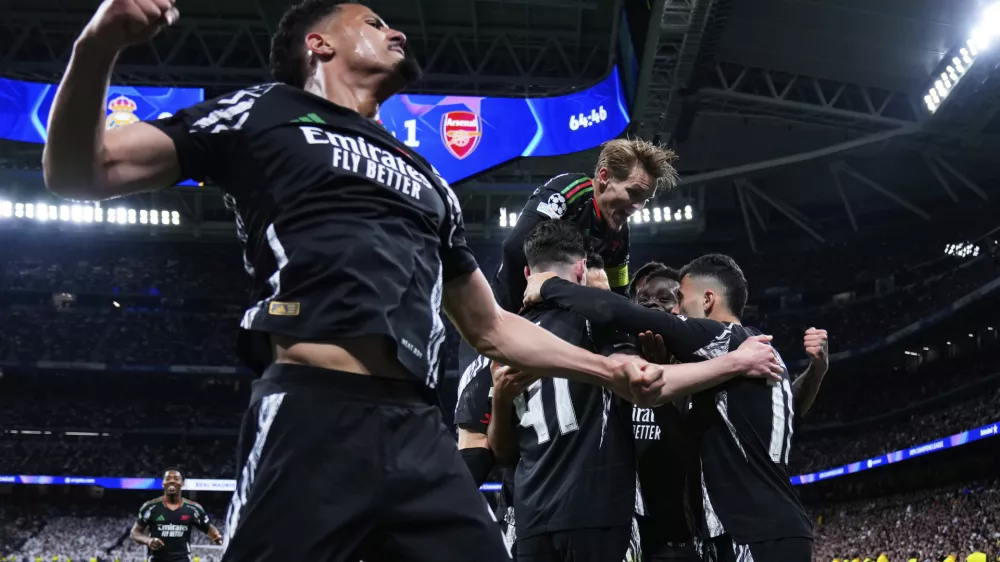 Arsenal players celebrate after Bukayo Saka, 2nd right, scored the opening goal during the Champions League quarterfinals second leg soccer match between Real Madrid and Arsenal at the Santiago Bernabeu stadium in Madrid, Wednesday, April 16, 2025. (AP Photo/Manu Fernandez)