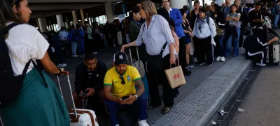 Travellers wait outside Atocha train station with their luggage after it was closed due to a power outage in Madrid, Spain, April 28, 2025. REUTERS/Susana Vera
