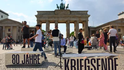 People walk beside mirrored blocks reading, "80 years of the end of the war", in front of Brandenburg Gate to mark the end of World War Two in Europe 80 years ago in Berlin, Germany, May 2, 2025. REUTERS/Fabrizio Bensch