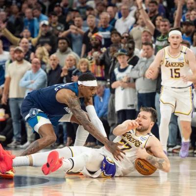 Apr 27, 2025; Minneapolis, Minnesota, USA; Los Angeles Lakers guard Luka Doncic (77) calls a timeout after stumbling on the defense of Minnesota Timberwolves forward Jaden McDaniels (3) in the fourth quarter during game four of first round for the 2025 NBA Playoffs at Target Center. Mandatory Credit: Matt Blewett-Imagn Images