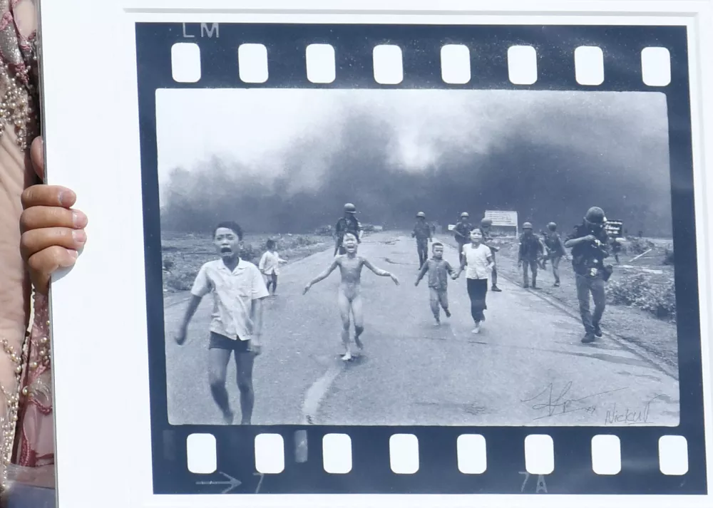 Pulitzer Prize-winning photographer Nick Ut (R), flanked by Kim Phuc, known as the 'Napalm Girl', shows his 1972 Vietnam war iconic photo as they wait to meet Pope Francis at the end of the weekly general audience in St. Peter s Square, Vatican on May 11, 2022.