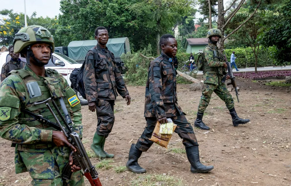 Rwandan security officers escort members of the Armed Forces of the Democratic Republic of the Congo (FARDC), who surrendered in Goma, eastern Democratic Republic of Congo following fighting between M23 rebels and the FARDC, in Gisenyi, Rwanda, January 27, 2025. REUTERS/Jean Bizimana