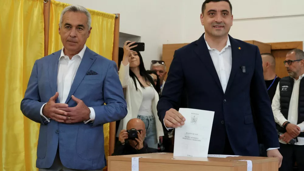 Presidential candidate George Simion votes as Calin Georgescu looks on at a polling station during the country's first round of the presidential election, in Mogosoaia, Romania, May 4, 2025. REUTERS/Louisa Gouliamaki