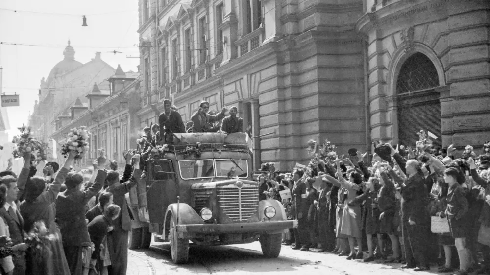 Množica s cvetjem pozdravlja partizansko vojsko, nekateri so se pripeljali s tovornjaki, Ljubljana, 9. maj 1945. Fotografija: Rudi Stopar, hrani Muzej novejše in sodobne zgodovine SlovenijePOZOR, NI ZA PONOVNO OBJAVO BREZ DOVOLJENJA MNSZS!!!