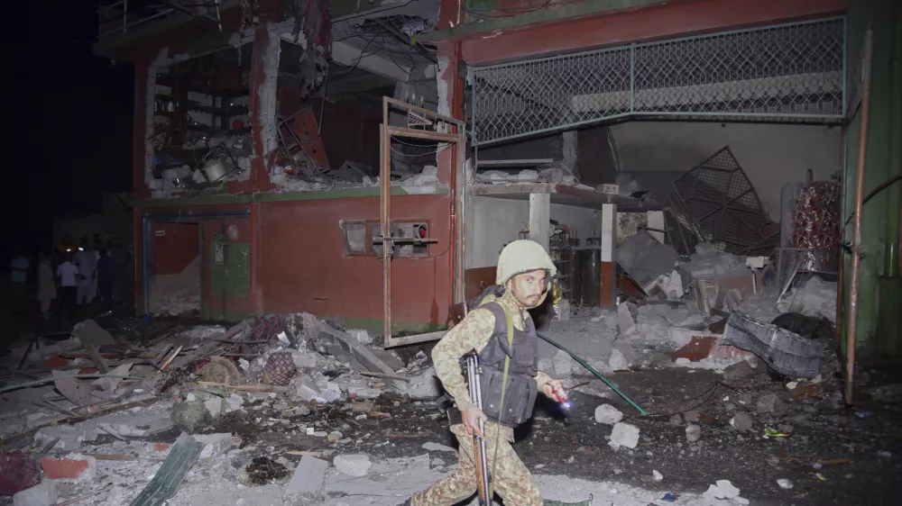 An army soldier examines a building damaged by a suspected Indian missile attack near Muzaffarabad, the capital of Pakistan controlled Kashmir, in Wednesday, May 7, 2025. (AP Photo/M.D. Mughal)