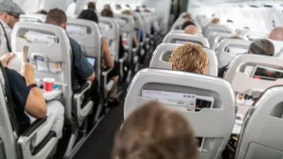 Interior of commercial airplane with passengers in their seats during flight.