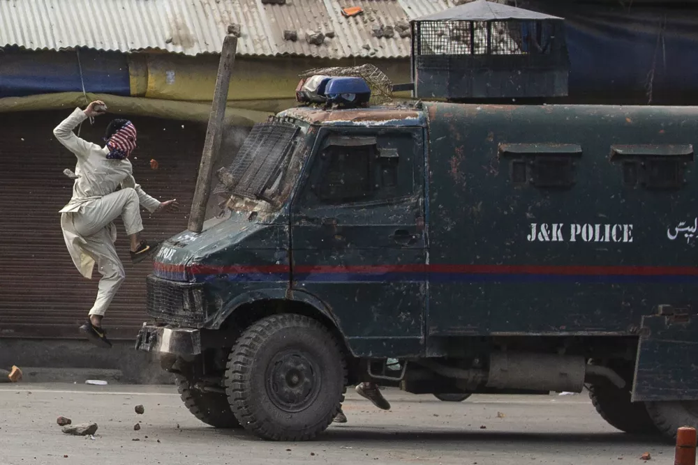 ﻿A masked Kashmiri protester jumps on the bonnet of an armored vehicle of Indian police as he throws stones at it during a protest in Srinagar, Indian controlled Kashmir, May 31, 2019. The image was part of a series of photographs by Associated Press photographers which won the 2020 Pulitzer Prize for Feature Photography. (AP Photo/Dar Yasin)